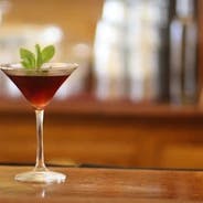 a glass of wine sitting on top of a wooden table